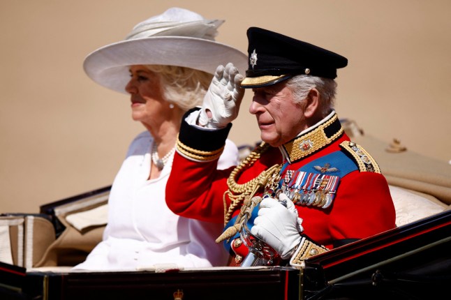 Britain's King Charles III salutes next to Britain's Queen Camilla as they arrive to Horse Guards Parade for the King's Birthday Parade, "Trooping the Colour", in London on June 14, 2025. The ceremony of Trooping the Colour is believed to have first been performed during the reign of King Charles II. Since 1748, the Trooping of the Colour has marked the official birthday of the British Sovereign. Over 1500 parading soldiers and almost 300 horses take part in the event. (Photo by BENJAMIN CREMEL / AFP) (Photo by BENJAMIN CREMEL/AFP via Getty Images)