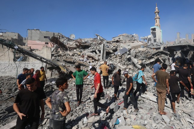 Palestinians inspect the site of an Israeli strike on the Bureij camp for Palestinian refugees in the central Gaza Strip on June 15, 2025. Gaza's civil defence agency said 16 people were killed in Israeli military operations in the Palestinian territory on June 15, most of them while waiting for aid.